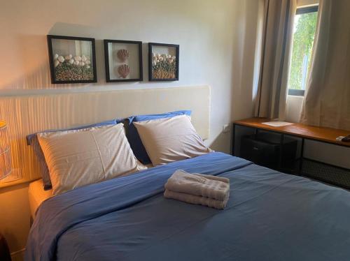 费尔南多 - 迪诺罗尼亚Oby Noronha的一间卧室配有一张带蓝色毯子的床和窗户。