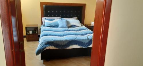 KitimēMENBi's Apartment的一间卧室配有一张带蓝色枕头的大床
