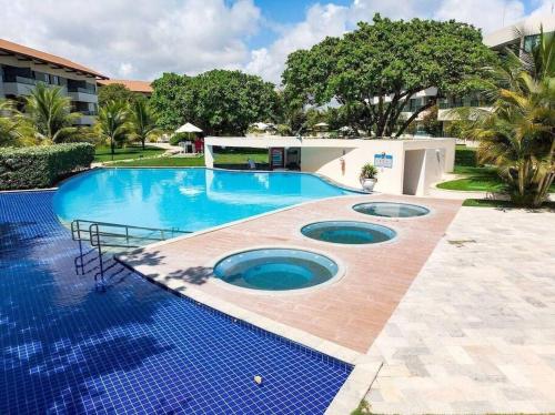 塔曼达雷Flat Beira Mar - Carneiros Beach Resort的庭院内一个蓝色瓷砖的大型游泳池