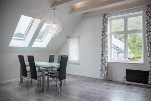 卑尔根Modern apartment 7 min to center的一间带桌椅和窗户的用餐室