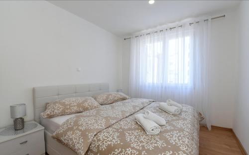 普洛切Apartman Roko的一间卧室配有一张带两条白色毛巾的床