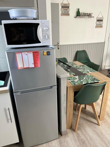 勒特雷波尔Gîte Lilou avec parking privé的桌子旁冰箱上的一个微波炉