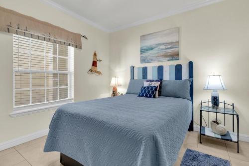 南帕诸岛Rain Dancer的一间卧室设有蓝色的床和窗户。