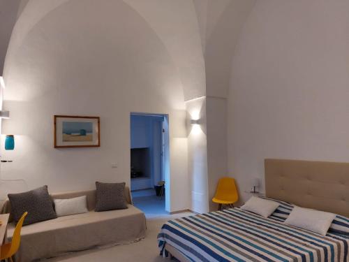 塔维亚诺Corte Petricore的一间卧室配有一张床和一张沙发