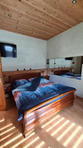 马蒂尼威尔Chez Pewee, beau duplex en ville, parc privé的一间卧室配有一张大木床。