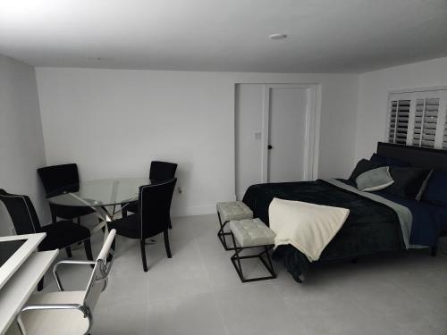 劳德代尔堡JBMANORS的卧室配有一张床和一张桌子及椅子