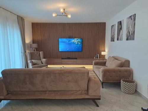 蒂瓦特Lux Apartment Jovanovic的客厅配有沙发、两把椅子和一台平面电视