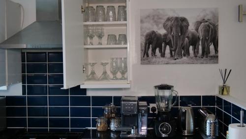 WolvertonMilton Keynes Luxury Short Stay House with WIFI and Free Parking的厨房配有带搅拌机和大象的台面,墙上挂着大象