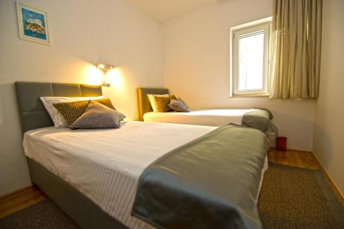 杜布罗夫尼克Apartment Duby的酒店客房设有两张床和窗户。
