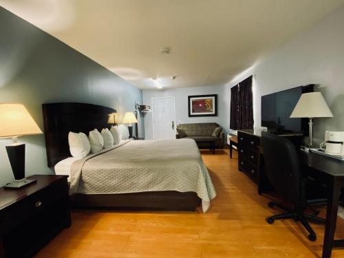 温莎Kenora Motel的酒店客房配有一张床、一张桌子和一把椅子。