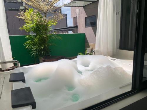 马六甲lmperio Residence Melaka - Private Indoor Hot Jacuzzi的窗户旁装满水的浴缸