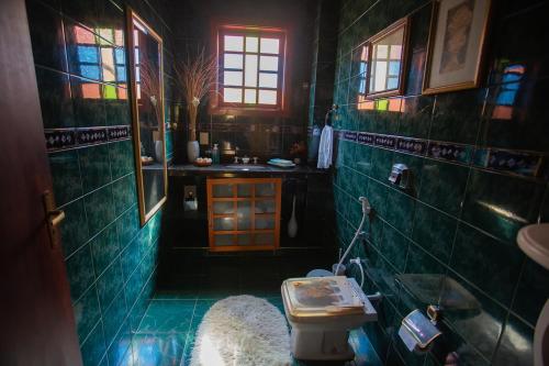 尼泰罗伊Casa a 50m da Praia de Itacoatiara Niteroi RJ的浴室设有绿色瓷砖墙壁和水槽。