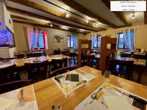 SchwartzbachL'estaminet De La Vallée的用餐室配有木桌和椅子