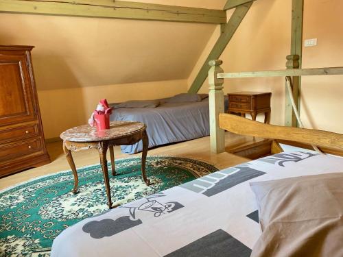 SchwartzbachL'estaminet De La Vallée的一间卧室配有一张床、一张桌子和一张床