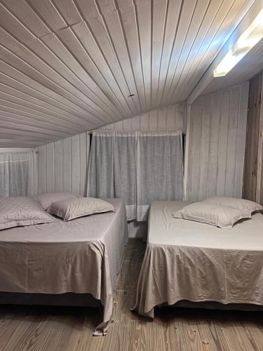 坎博里乌Sítio do Vô Pisco的一间卧室设有两张床,铺有木地板