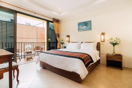 卡塔海滩Kata Silver Sand的一间带大床的卧室和一个阳台