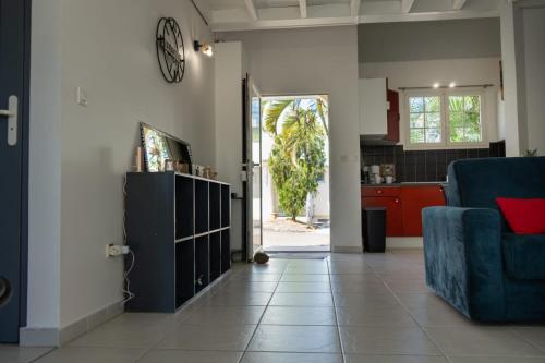 圣安娜La Villa Noémie - Parking - Proche des Plages的一间带蓝色沙发的客厅和一间厨房