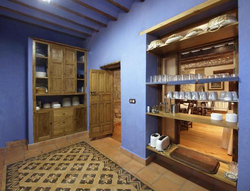 瓜迪克斯科尔蒂霍拉塔拉乡村民宿的厨房设有蓝色的墙壁和木制橱柜。
