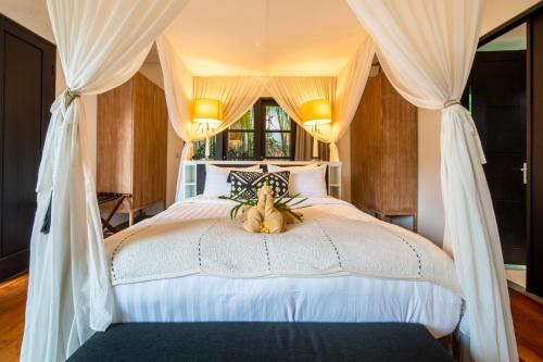 塞米亚克Lotus Luxury Villa Seminyak的一间卧室,床上有泰迪熊