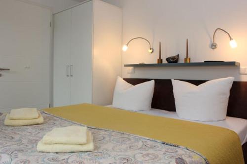 NeuhausAquamarin Ostseetraumsuite 08的一间卧室配有一张大床和两条毛巾
