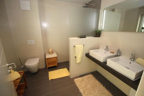 NeuhausAquamarin Ostseetraumsuite 10的浴室设有2个水槽、卫生间和镜子。