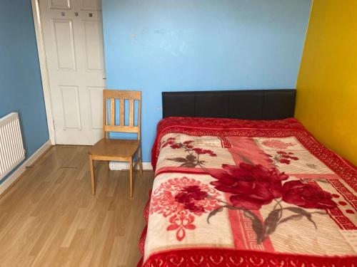 布莱克浦伍德菲尔德酒店的一间卧室配有一张带红色毯子和椅子的床