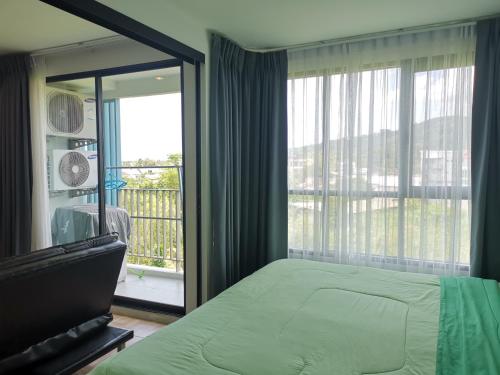 普吉镇5 Floor - Centrio Condominium in Phuket Town - 30 mins to beaches的一间卧室设有一张床和一个大窗户
