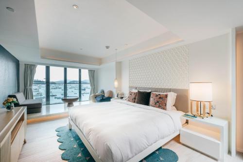 香港The Pier Hotel的一间卧室设有一张大床和一个大窗户