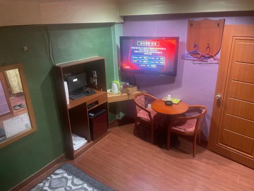 首尔Grace Motel的客房设有书桌和带电视的桌子。