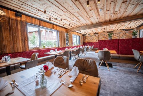 玛丽亚阿尔姆隆宁霍夫酒店的餐厅拥有木墙和桌椅