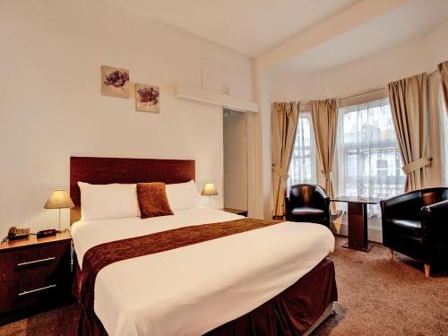 大雅茅斯The Waverley Hotel的酒店客房设有一张大床和一张书桌。