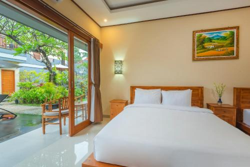 勒吉安Liliy Guest House Kuta - Badung的一间卧室设有一张床和一个大窗户