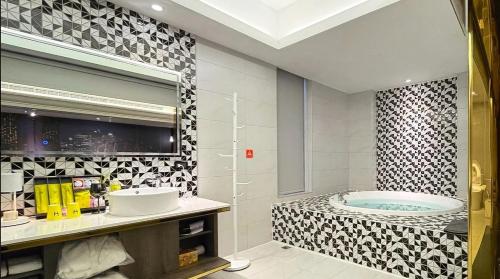 竹北H Motel玺悦国际精品旅馆的带浴缸和盥洗盆的浴室