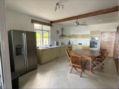 托舵道斯2 bedroom Apartment -Villa Ibiza的厨房配有木桌和冰箱。