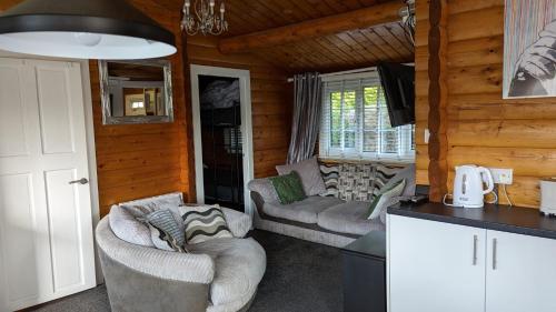 特兹西尼德Snowdonia Log cabin的小木屋内带两张沙发的客厅