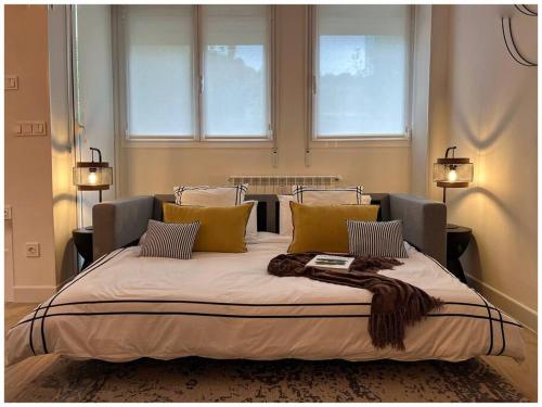 圣塞瓦斯蒂安Elegance Lifestyle - Parking Gratuito!的一张大床,位于带两个窗户的房间
