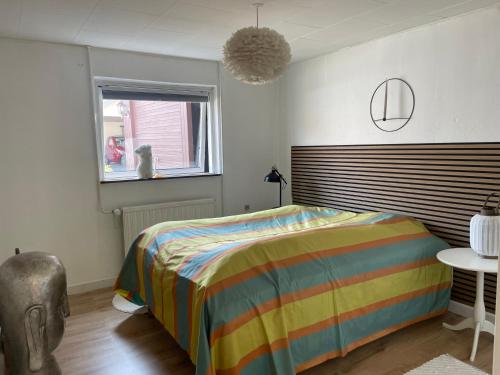 斯文堡Cozy Nature House的一间卧室配有一张带彩色条纹毯子的床