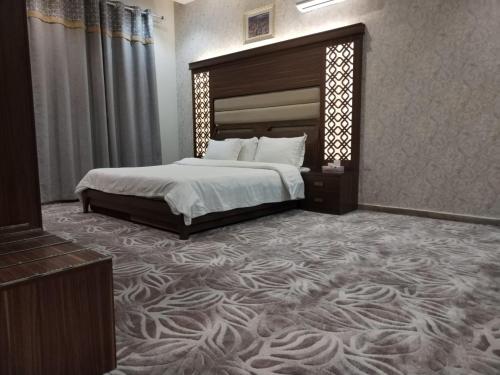 海米斯穆谢特امارلس للشقق الفندقية的一间卧室配有一张大床和一张大地毯