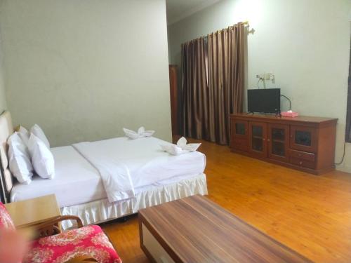 巴利盖Hotel Ompu Herti的酒店客房设有两张床和电视。