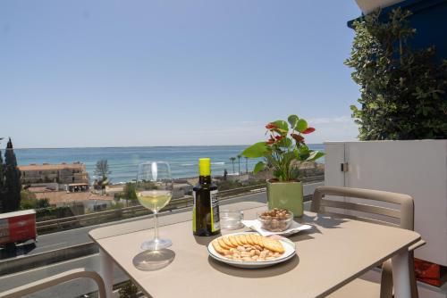 Estepona彼德拉帕洛玛酒店的一张桌子,上面放着一杯葡萄酒和一盘食物