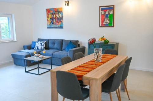 尼亚卢卡Apartment Leo Blue的客厅配有桌子和蓝色沙发