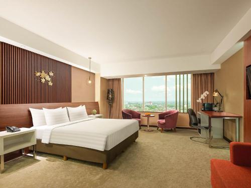 日惹阿拉纳日惹酒店与会议中心的配有一张床和一张书桌的酒店客房