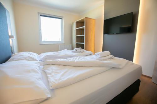 施韦夏特Das Reinisch Just Rooms的一间卧室配有两张带白色床单的床