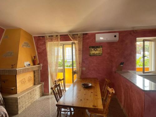 拉契亚Dimora Pina sul mare的一间带木桌的用餐室和一间厨房