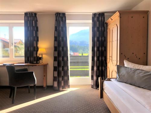 费斯恩洛特费西巴桑纳贝切尔酒店的一间卧室配有一张床、一张书桌和一个窗户。
