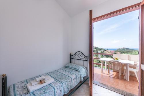 奇亚Villa Leonardo Sud Sardegna的一间卧室配有一张床,阳台配有桌子