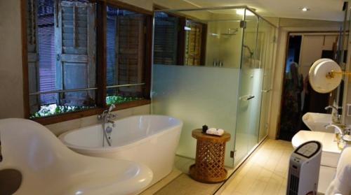 马六甲The Opposite Place的大型浴室设有浴缸和淋浴。