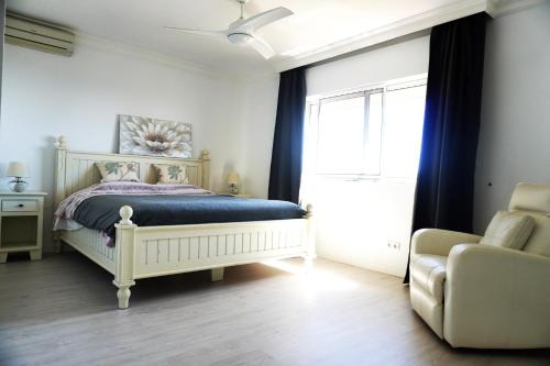 马拉加Villa Seaview Suncoast Luxury的卧室配有床、椅子和窗户。