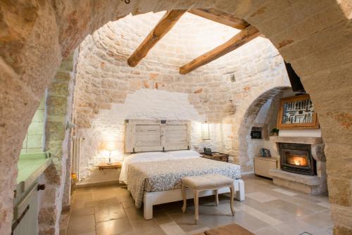 阿尔贝罗贝洛Trulli Holiday Albergo Diffuso的卧室配有一张石墙床