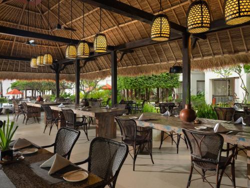 圣吉吉Sudamala Resort, Senggigi, Lombok的室外餐厅设有桌椅和灯光
